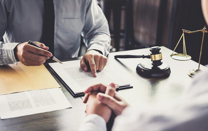 Lawyer meeting with a client at a desk to discuss their personal injury case.